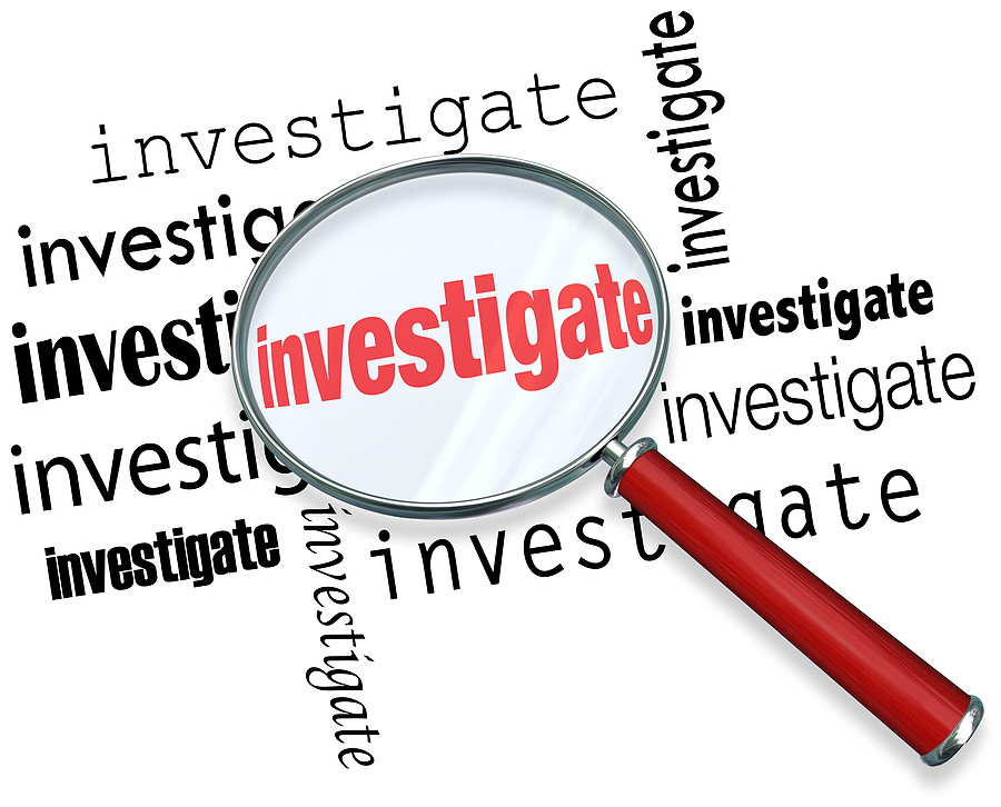 Magnfiying glass on the word investigate to illustrate detective